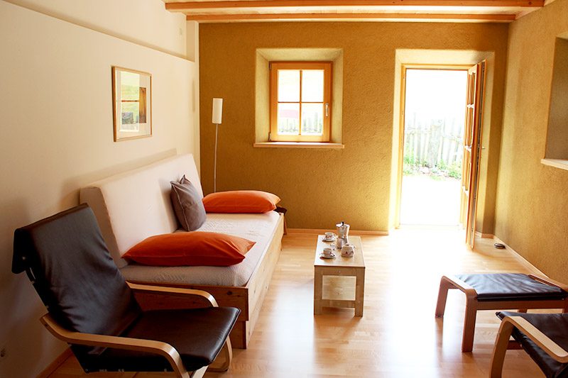 Gemütliches Wohnzimmer mit Sitzecke und Balkonzugang