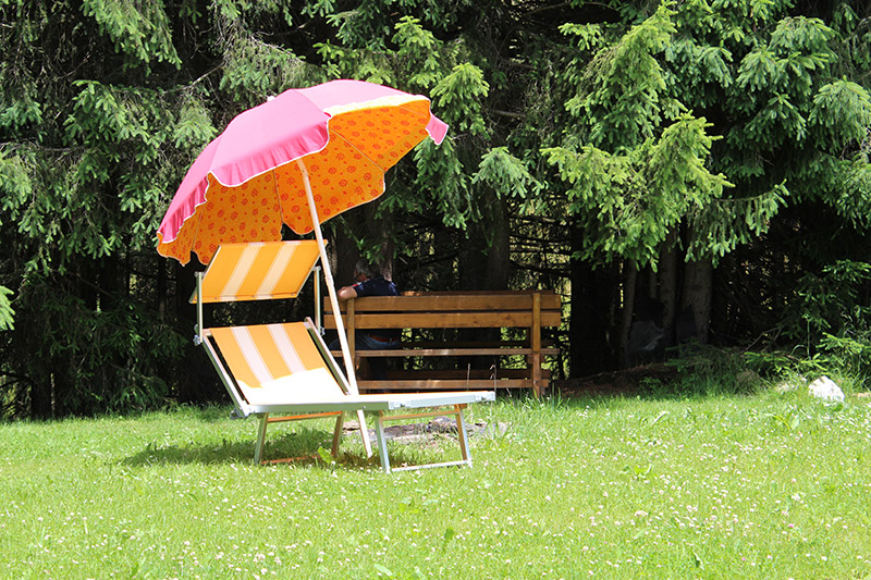 Liegestuhl mit Sonnenschirm im Garten